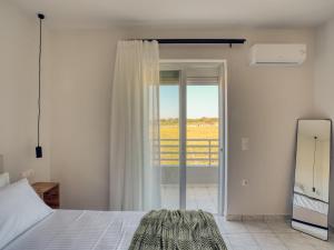 a bedroom with a bed and a sliding glass door at Aurelea Luxury Apartments in Kos