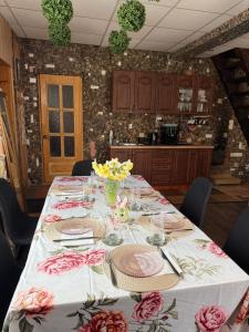 a table with a white table cloth and flowers on it at Guest house ''Stropiki'' with Sauna and hot Tub in Daugavpils