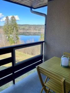 a balcony with a table and a view of a lake at Appartement en bord de lac in Malbuisson