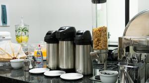 a kitchen counter with two silver kettles on a counter at Terraço Plaza Hotel in Jabuticabal