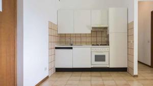 a kitchen with white cabinets and a stove top oven at Residenza Pierre & Vacances Luni Mare in Luni