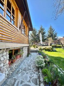 a stone walkway in front of a house with plants at Guest House Rila in Govedartsi