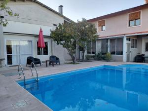 ein Swimmingpool vor einem Haus in der Unterkunft PATO BLANCO in Ciudad Lujan de Cuyo