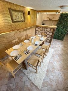 a dining room with a wooden table and chairs at Guest House Rila in Govedartsi