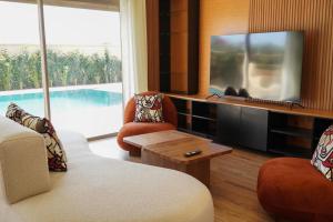 a living room with a tv and a pool at villa Tarik with private pool in El Aïn