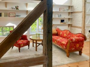 a living room with a red couch and a table at Apartment In A Converted 1875 Creamery in Travenhorst