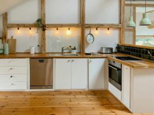 a kitchen with white cabinets and a wooden floor at Apartment In A Converted 1875 Creamery in Travenhorst