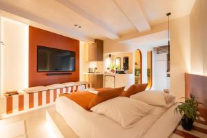 ein Wohnzimmer mit einem weißen Sofa und einem Fernseher in der Unterkunft minuit - Love Room avec jacuzzi privatif et hammam Marseille Aix in Vitrolles