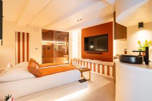 ein Hotelzimmer mit Bett und Fernseher in der Unterkunft minuit - Love Room avec jacuzzi privatif et hammam Marseille Aix in Vitrolles