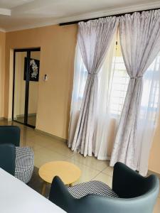 a living room with a large window and chairs at Aurum Stays in Gaborone