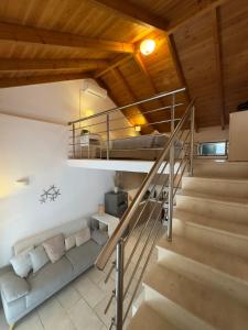 a living room with a staircase and a couch at Tousso Apartment Loggos in Longós +3 photos