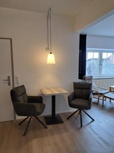 a living room with a table and two chairs at Heimathafen in Büsum