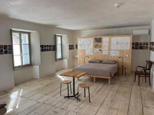 a bedroom with a bed and a table and chairs at Casa Piumogna in Faido