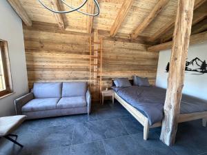 a bedroom with a bed and a couch in a room at Le mazot in Lens