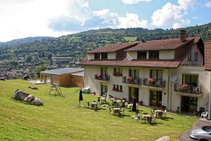 a house on a hill with tables and chairs at Hôtel Restaurant & Bien-être Le Chalet des Roches in La Bresse +50 photos