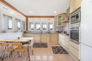 a kitchen with wooden cabinets and a table and chairs at Casa Francisco y Carmen in Alfarrás