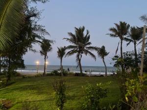 a view of a beach with palm trees and the ocean at Waves - for Family & Married Couples only in Mahabalipuram +16 photos