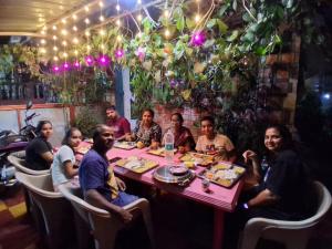 a group of people sitting around a table in a restaurant at Om Datta Krupa Niwas Cottage in Mahabaleshwar