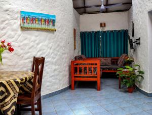 a patio with a table and chairs and a painting on the wall at Tradewinds Lodge in Diani Beach