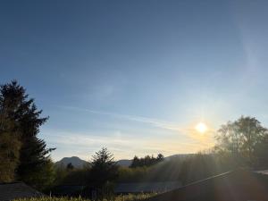 a view of the sun rising over the trees at Fernleys Place in Trawsfynydd