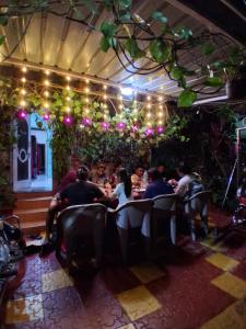 a group of people sitting at a table in a restaurant at Om Datta Krupa Niwas Cottage in Mahabaleshwar