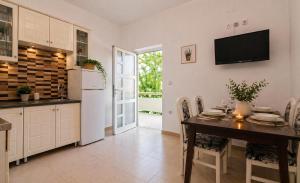 a kitchen with a table and a refrigerator at Apartman Ivana in Kruševo