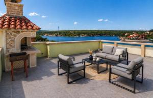 a patio with a fireplace and chairs and a table at Apartman Ivana in Kruševo