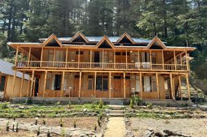a large wooden house with a roof at SAANJH, Shangarh in Shangarh
