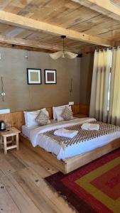 a large bed in a room with a wooden ceiling at SAANJH, Shangarh in Shangarh