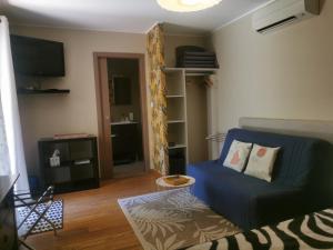 a living room with a blue couch and a tv at U Muzzelo in Oletta