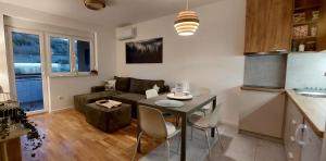 a kitchen and living room with a table and a couch at My Life 20 - Green Hill in Soko Banja
