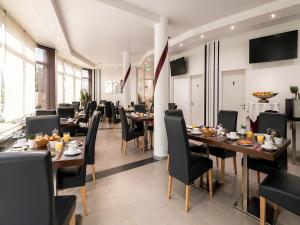 a dining room with tables and chairs in a restaurant at Turmhotel Rhein-Main - klimatisierte Apartments in Dreieich