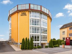 a tall yellow and white building with a train hotel at Turmhotel Rhein-Main - klimatisierte Apartments in Dreieich