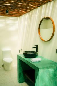 a bathroom with a sink and a mirror on the wall at Asem Bungalows in Kuta Lombok
