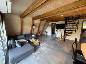 a living room with a blue couch and a wooden ceiling at Dachzelt Oase Damp in Damp
