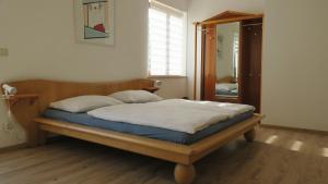 a bedroom with a bed with a wooden frame and a mirror at Tildes Apartments in Reifnitz