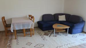 a living room with a blue couch and a table at Tildes Apartments in Reifnitz