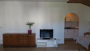 a living room with a tv on a white cabinet at Tildes Apartments in Reifnitz