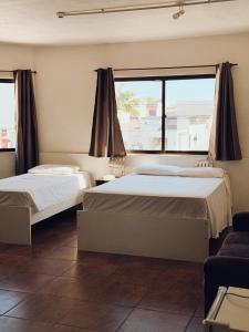 a bedroom with two beds and a large window at Arpini Hotel in Rio Grande
