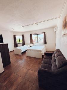 a large room with two beds and a couch at Arpini Hotel in Rio Grande