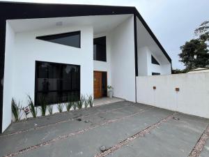 a white house with a black and white facade at Casa moderna em Itapoá SC in Itapoa