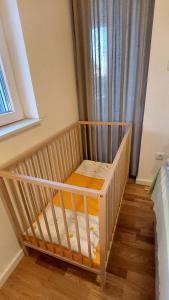 a crib in a room with a window at My Life 20 - Green Hill in Soko Banja