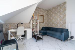 a living room with a blue couch and a desk at Perła Bałtyku in Gdańsk