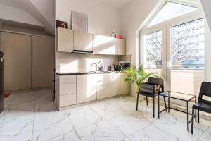 a kitchen with white cabinets and a table and chairs at Perła Bałtyku in Gdańsk