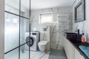 a white bathroom with a toilet and a sink at Perła Bałtyku in Gdańsk