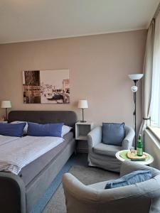 a bedroom with a bed and a couch and a chair at Heimathafen in Büsum