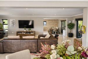 a living room with a brown leather couch at Villa on Ibis in Cape Town