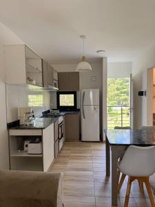 a kitchen with a refrigerator and a table with chairs at Aires de Laguna in Chascomús