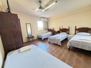 a room with three beds and a mirror at Abaeté Palace Hotel in Abaeté +30 photos