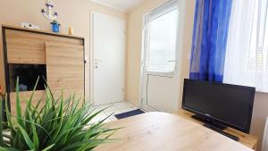 a living room with a table and a flat screen tv at Stettiner Str 6b in Grömitz